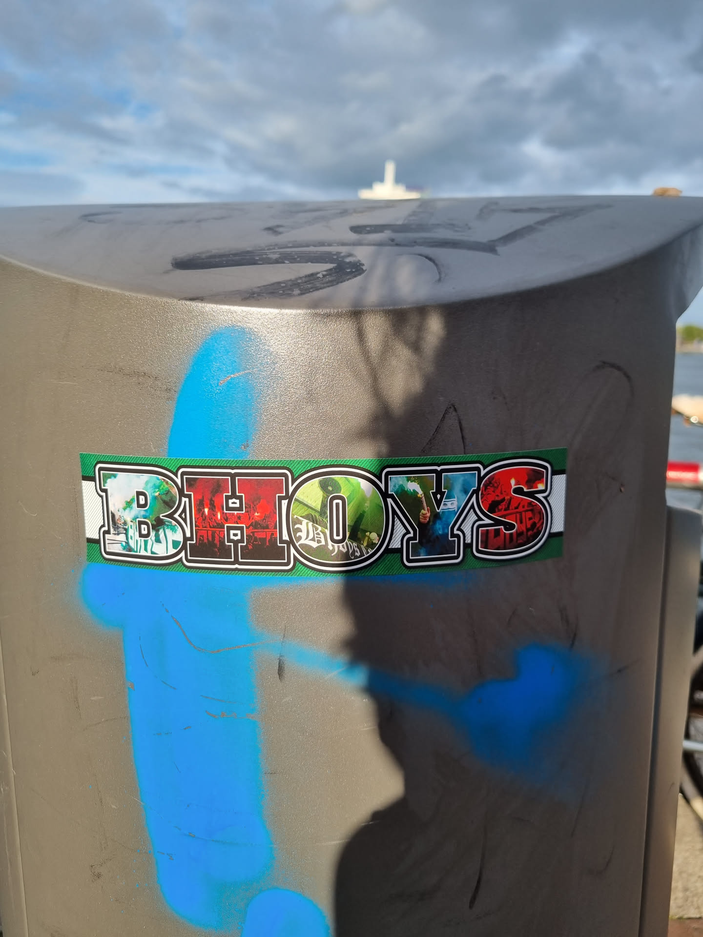 A sticker with the word BHOYS in large letters. The letters are decorated with various images. The sticker is placed on a gray surface.