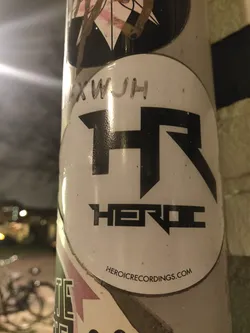 Round sticker with the Heroic Recordings logo. The logo is a stylized "HR" with the word "HEROIC" underneath. The website HEROICRECORDINGS.COM is printed at the bottom of the sticker.