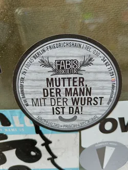 Round sticker with the text "Mutter, der Mann mit der Wurst ist da!" (Mother, the man with the sausage is here!),  Fabis Esskultur logo and contact info. It mentions sustainability, freshness and regionality.