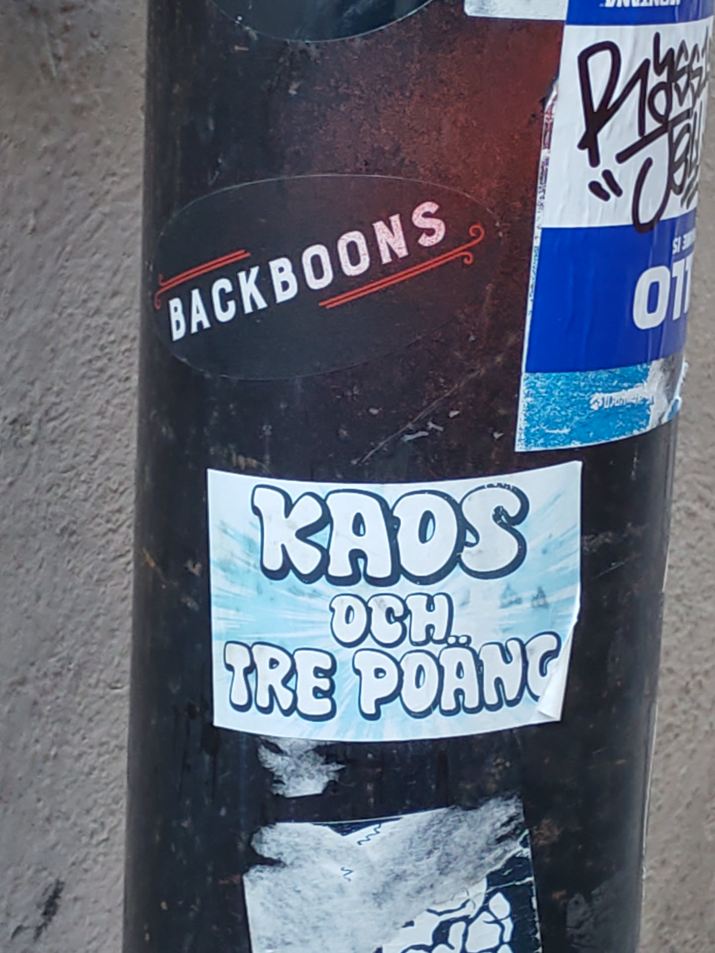 A sticker with the text "KAOS OCH TRE POÄNG" which translates to "Chaos and three points" in Swedish. The text is stylized in a retro, cartoonish font with a light blue background. 