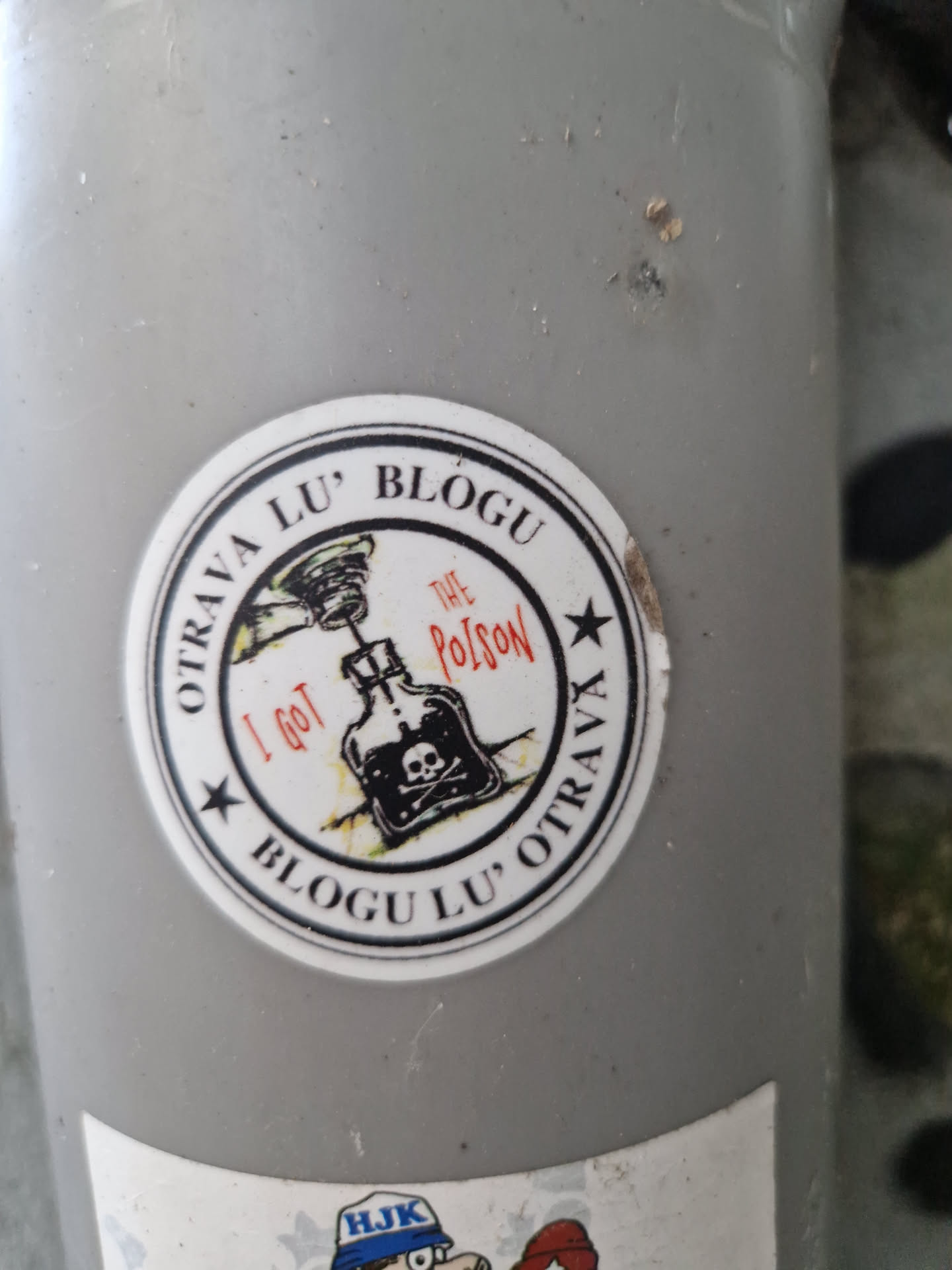 Round sticker with a skull and crossbones on a poison bottle. The text says Blogu Lu' Otrava and I got the poison in a circular design.