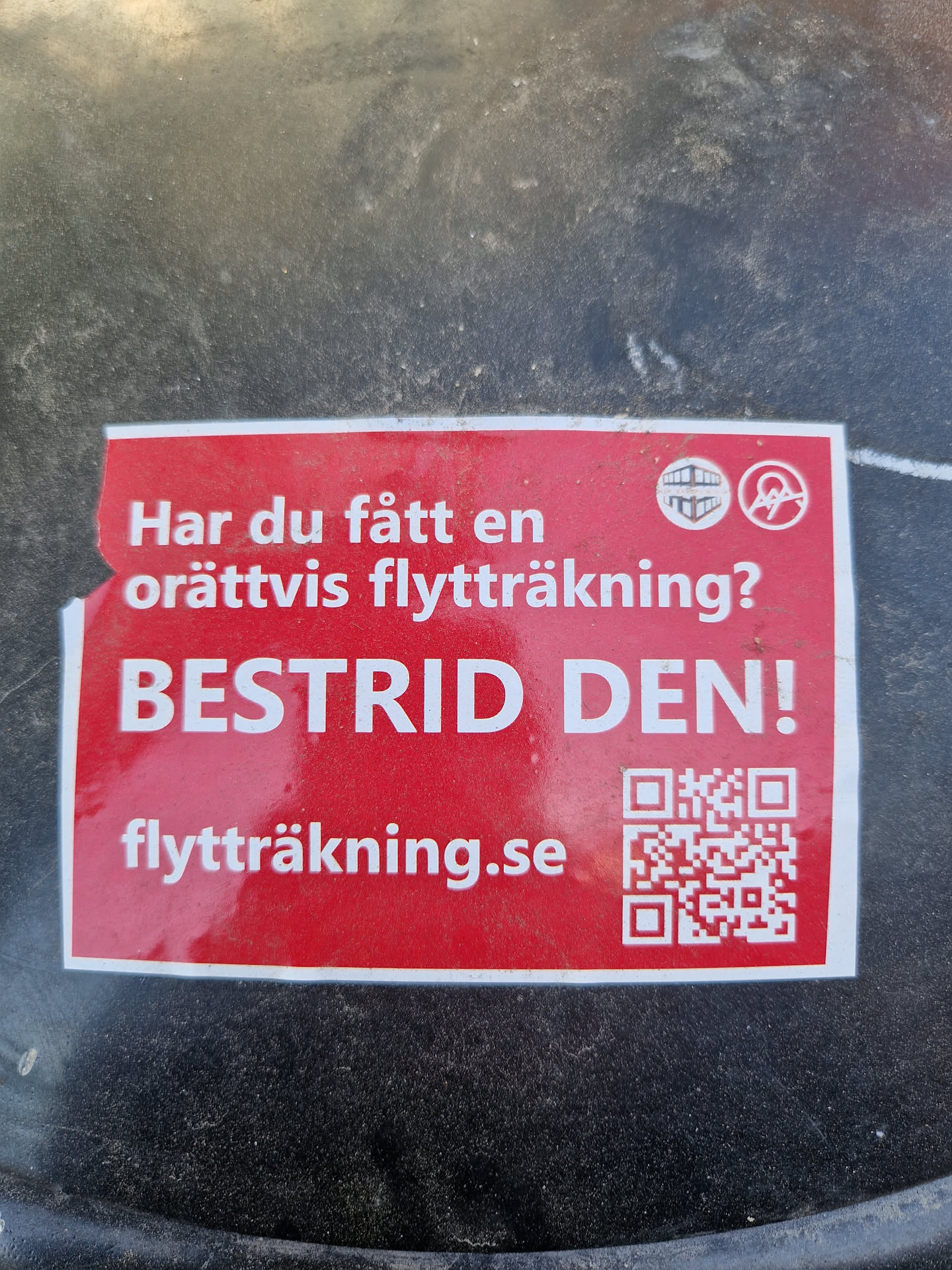 Red sticker with text in Swedish.  It asks if you've received an unfair moving invoice and urges you to contest it.  It also includes a QR code and a website address.