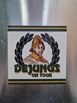 A sticker featuring a man in a helmet and a laurel wreath, with the text 'DEJUNG'S ON TOUR'.
