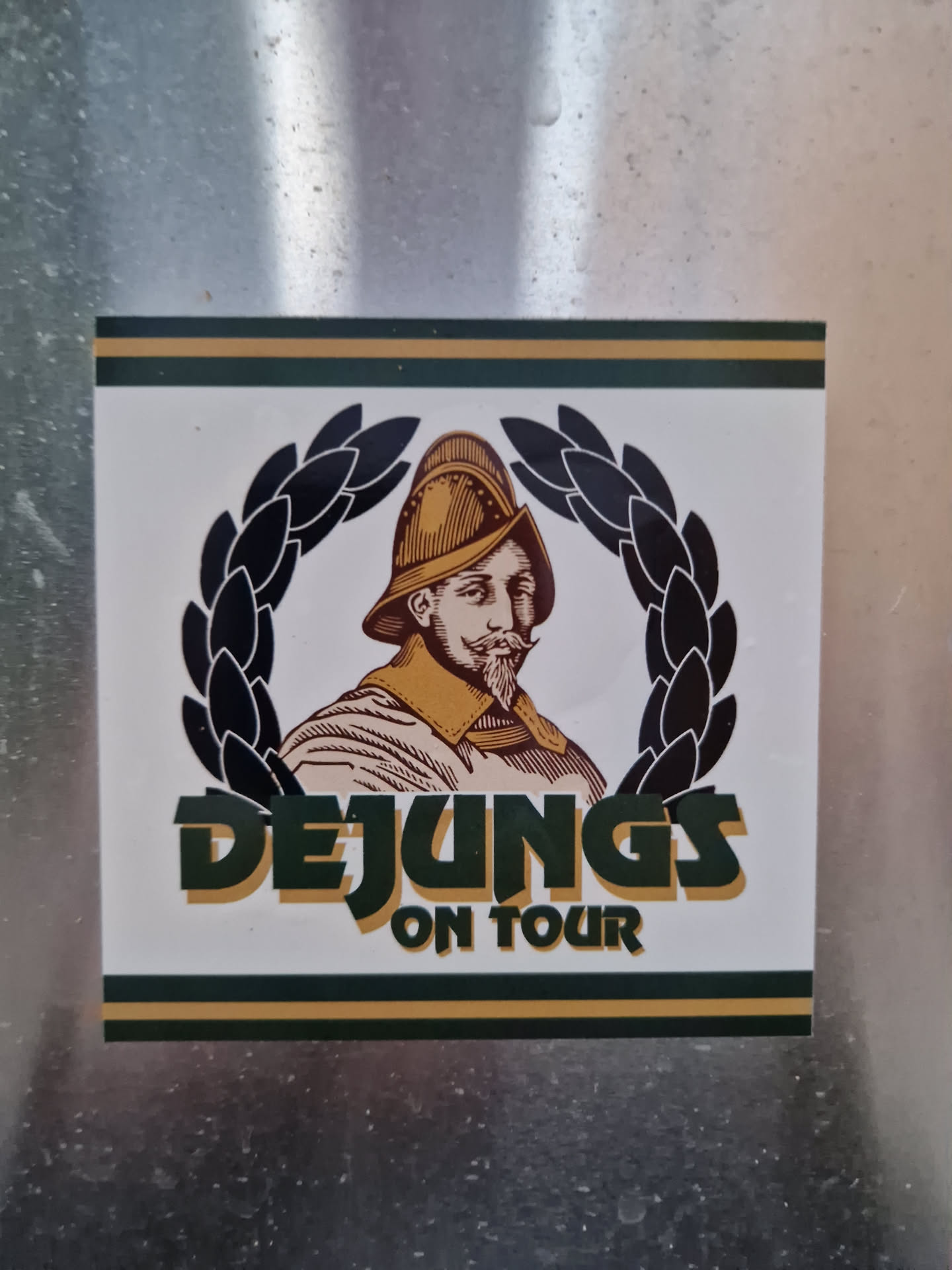 A sticker featuring a man in a helmet and a laurel wreath, with the text 'DEJUNG'S ON TOUR'.