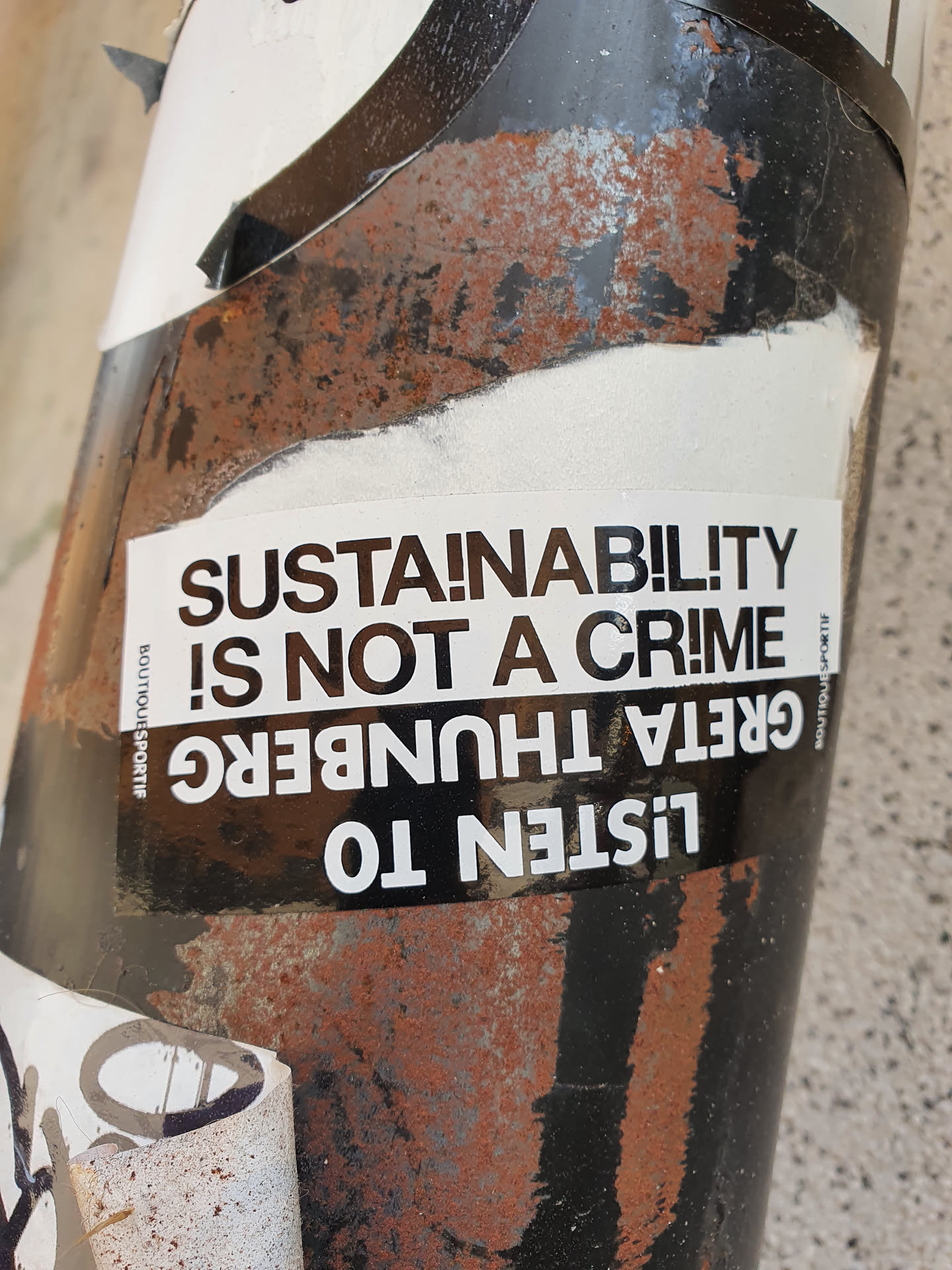 A sticker featuring a quote from Greta Thunberg. The sticker is attached to a rusty surface. The text is in black and white.