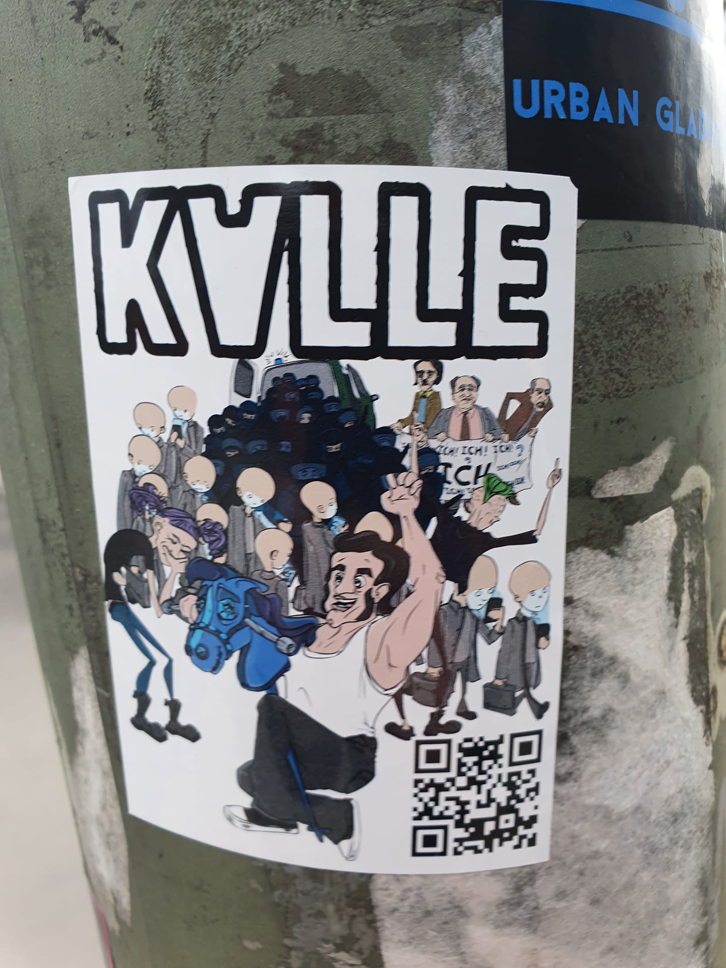 A sticker featuring a cartoon illustration of a man riding a rocking horse, surrounded by a crowd of bald figures and other characters. The illustration appears to be satirical or humorous in nature. The sticker has a QR code at the bottom.