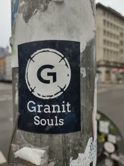 A dark blue sticker with a white circle containing the letter 'G' and the text 'Granit Souls'. The sticker appears to be affixed to a pole.