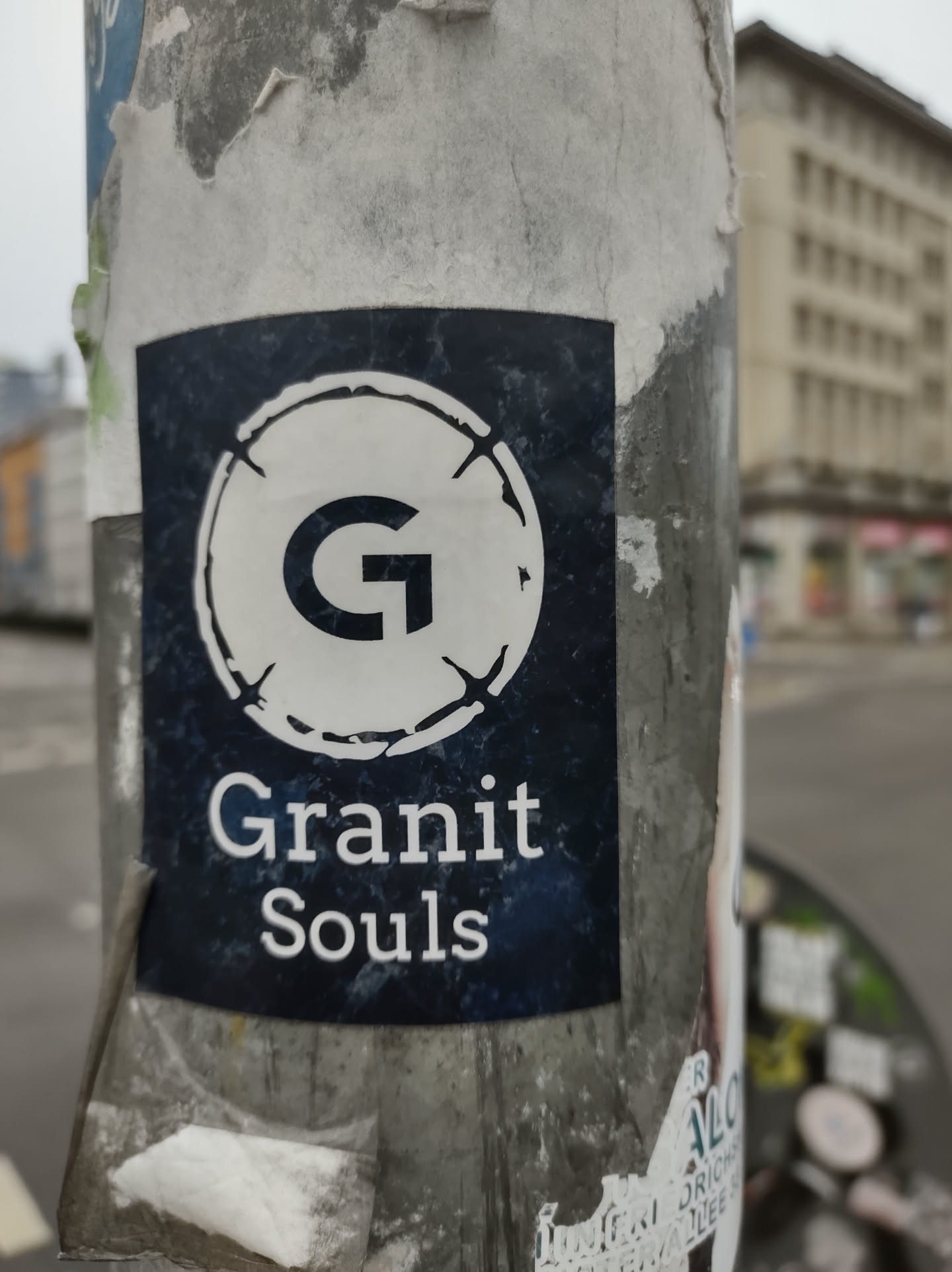 A dark blue sticker with a white circle containing the letter 'G' and the text 'Granit Souls'. The sticker appears to be affixed to a pole.
