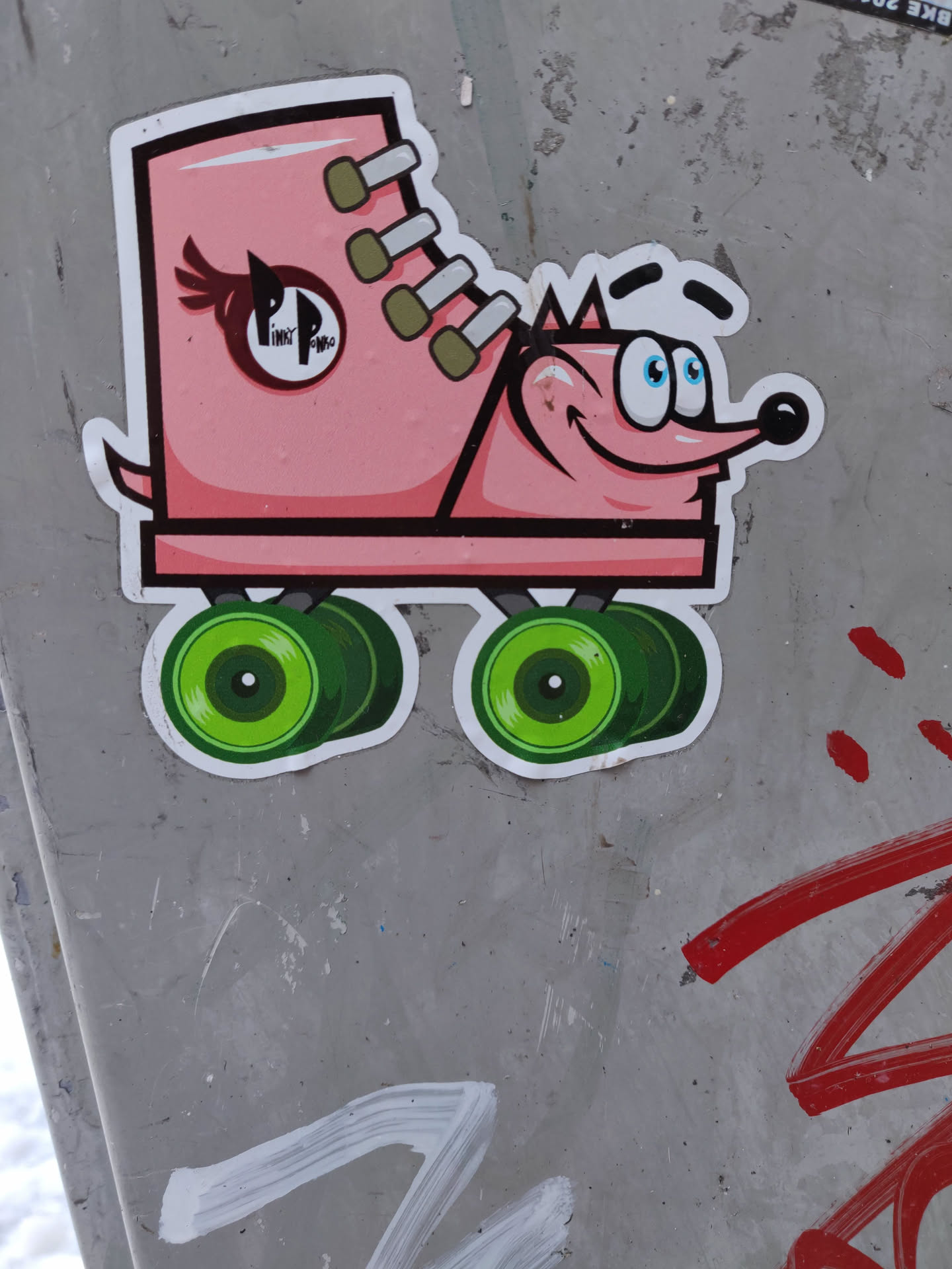 A pink roller skate with a cute critter face. The skate has green wheels and laces. There is a logo on the side of the skate that says Pink Panther.