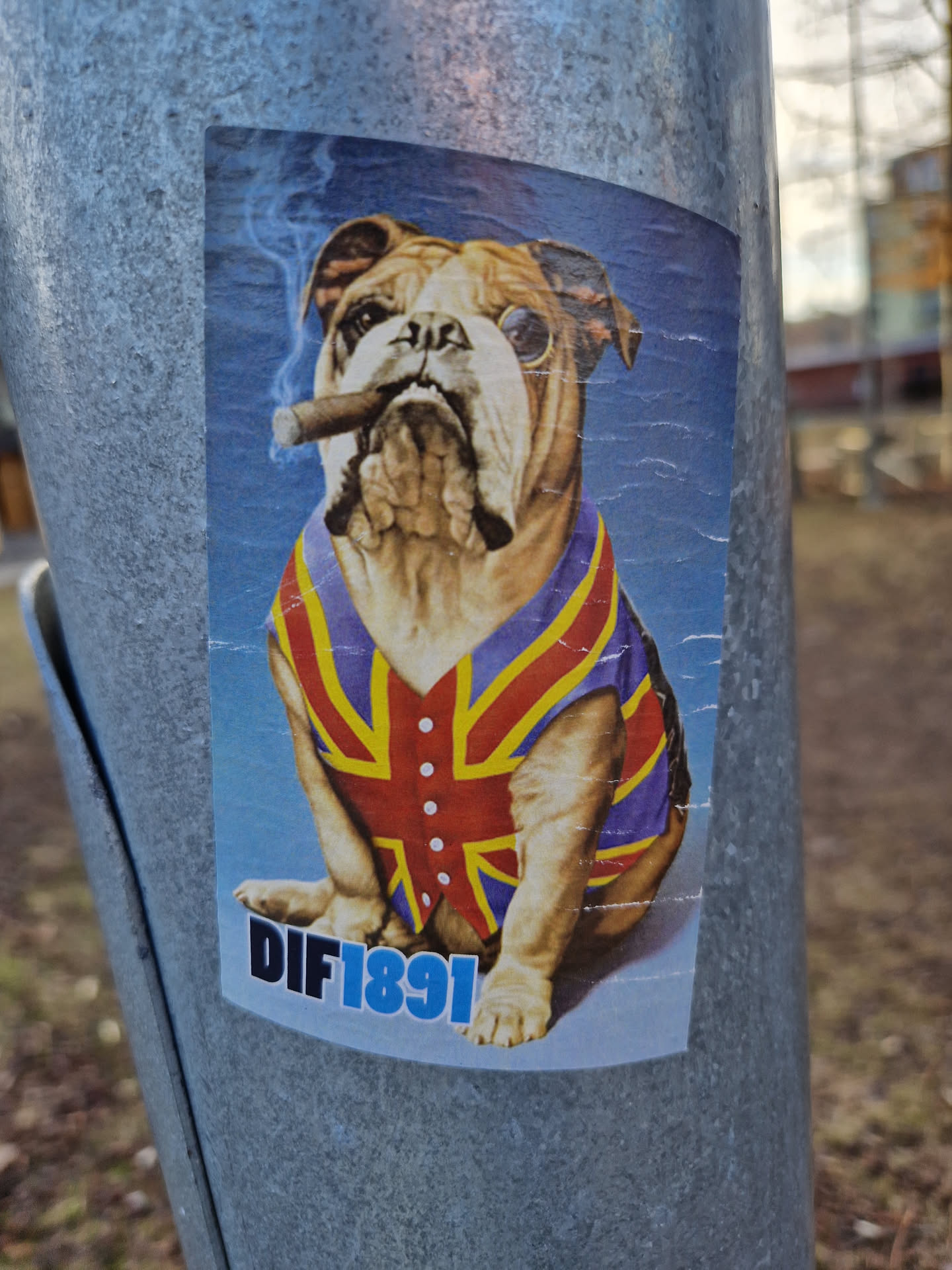 A sticker featuring a bulldog in a Union Jack-themed outfit, smoking a cigar.  The sticker has the text 'DIF1891' at the bottom.