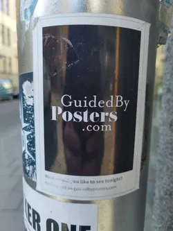 A sticker for Guided By Posters. The sticker has a dark background with the website name in white text.  Below is a small line of text that says, "What would you like to see tonight? Get inspired on guidedbyposters.com"