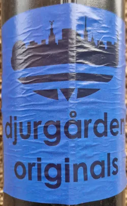 A blue sticker with a black silhouette of a city skyline and the text "Djurgården Originals".