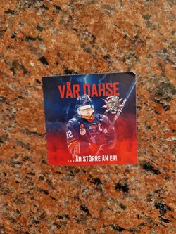 A hockey sticker featuring a player in action. The text on the sticker translates to "OUR DAHSE ... IS BIGGER THAN ERI."