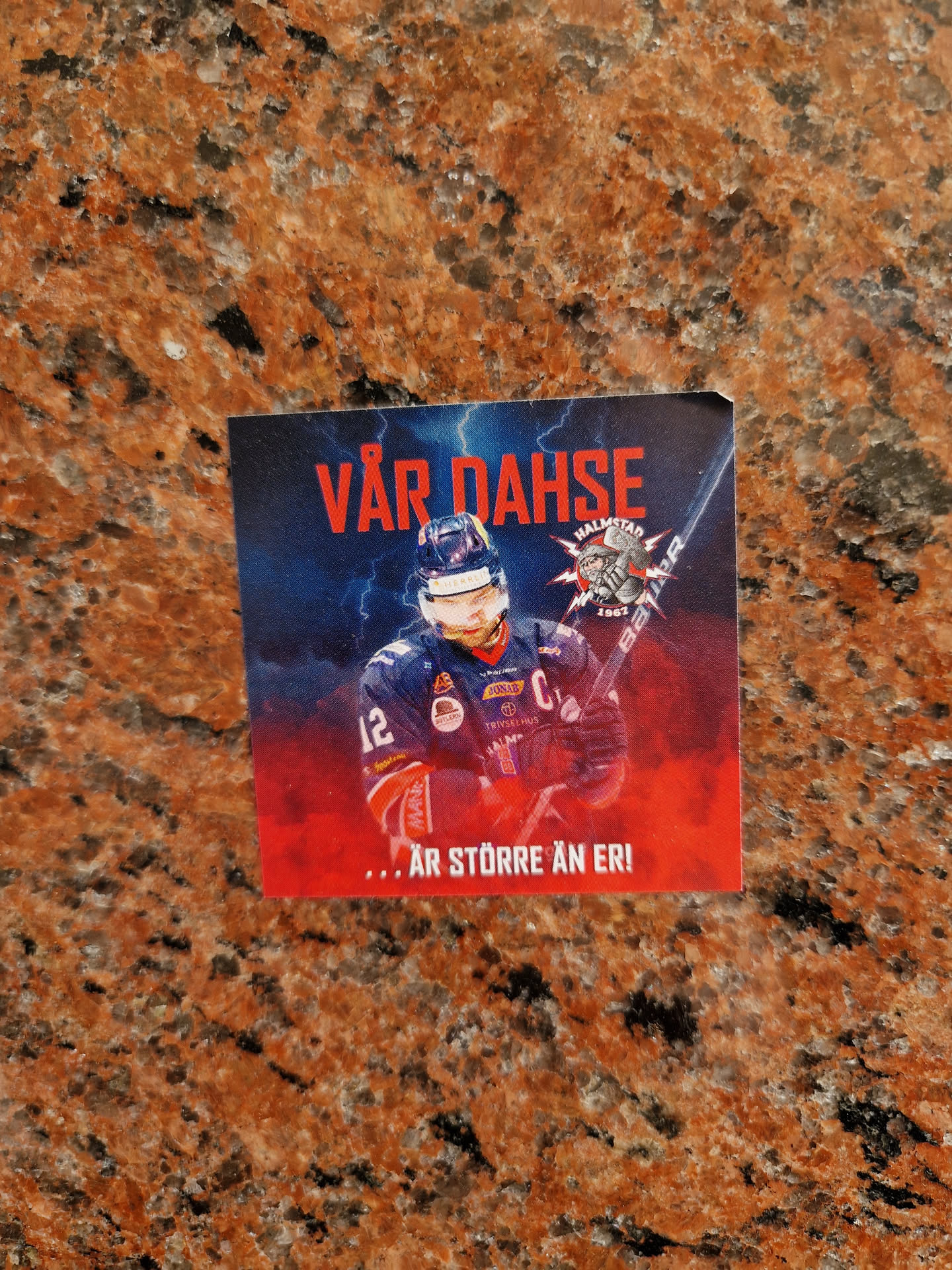 A hockey sticker featuring a player in action. The text on the sticker translates to "OUR DAHSE ... IS BIGGER THAN ERI."
