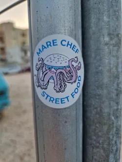 A sticker featuring an illustration of an octopus holding a bowl of food. The text 'MARE CHEF STREET FOOD' is written around the illustration.