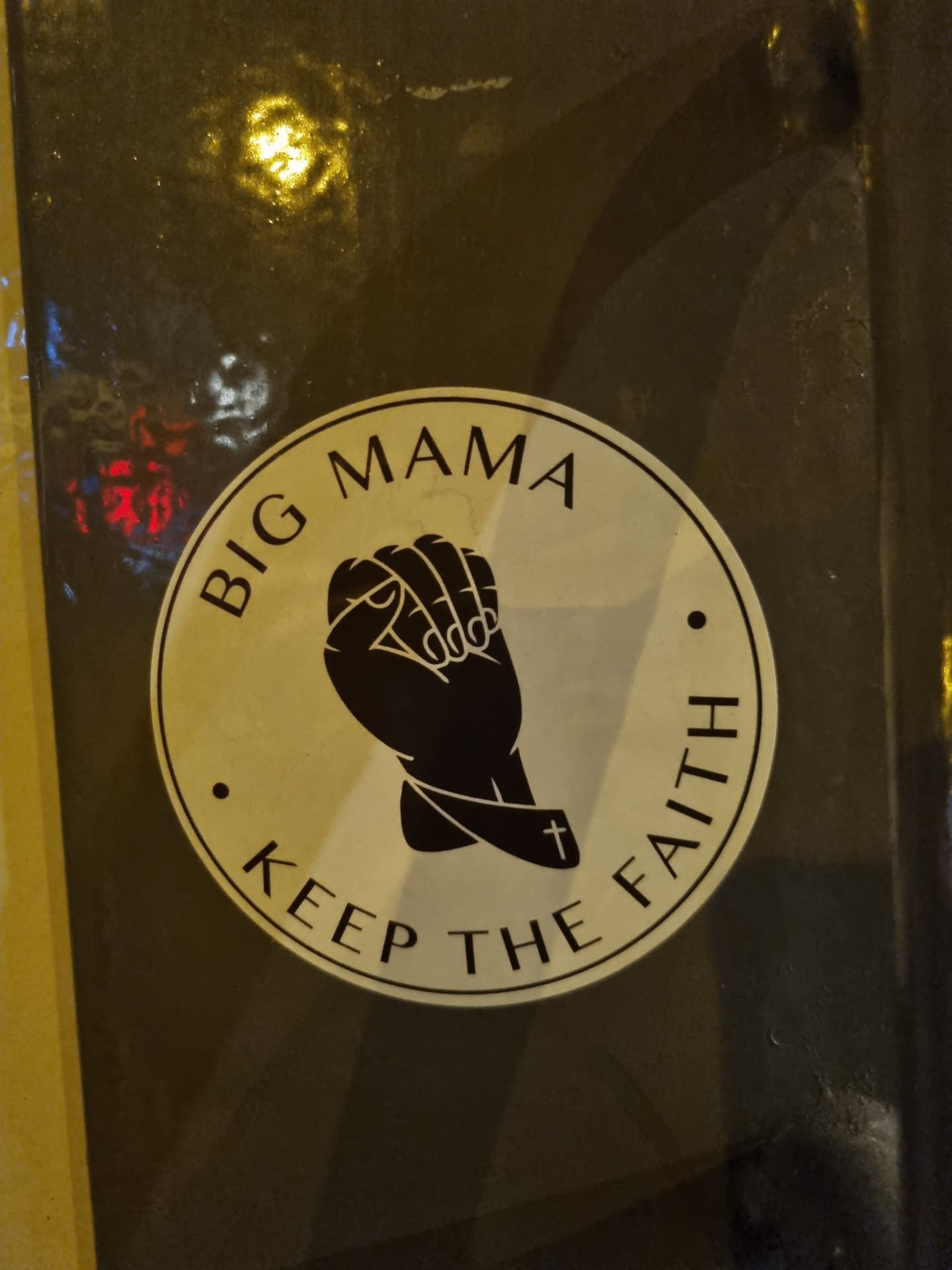A round sticker with a black and white design. It features two hands clasped together in prayer, with a cross on one wrist. The text "Big Mama" is written at the top and "Keep the Faith" at the bottom.
