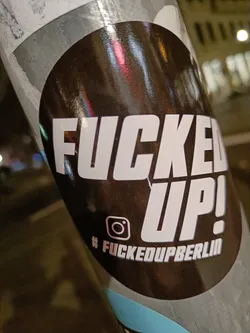 A black and white sticker with the text "FUCKED UP!" in bold white letters on a black background.  Below the text is an Instagram logo and the hashtag #fuckedupberlin.