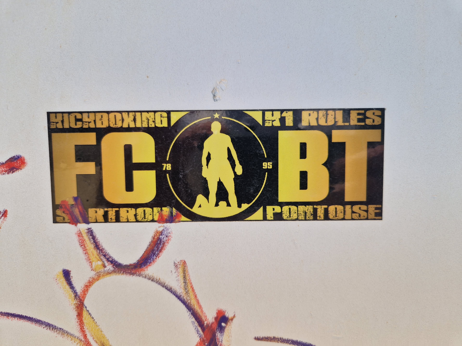 A yellow and black kickboxing club sticker with the logo FCBT, the city Pontoise and the text "Kickboxing" and "K1 rules".