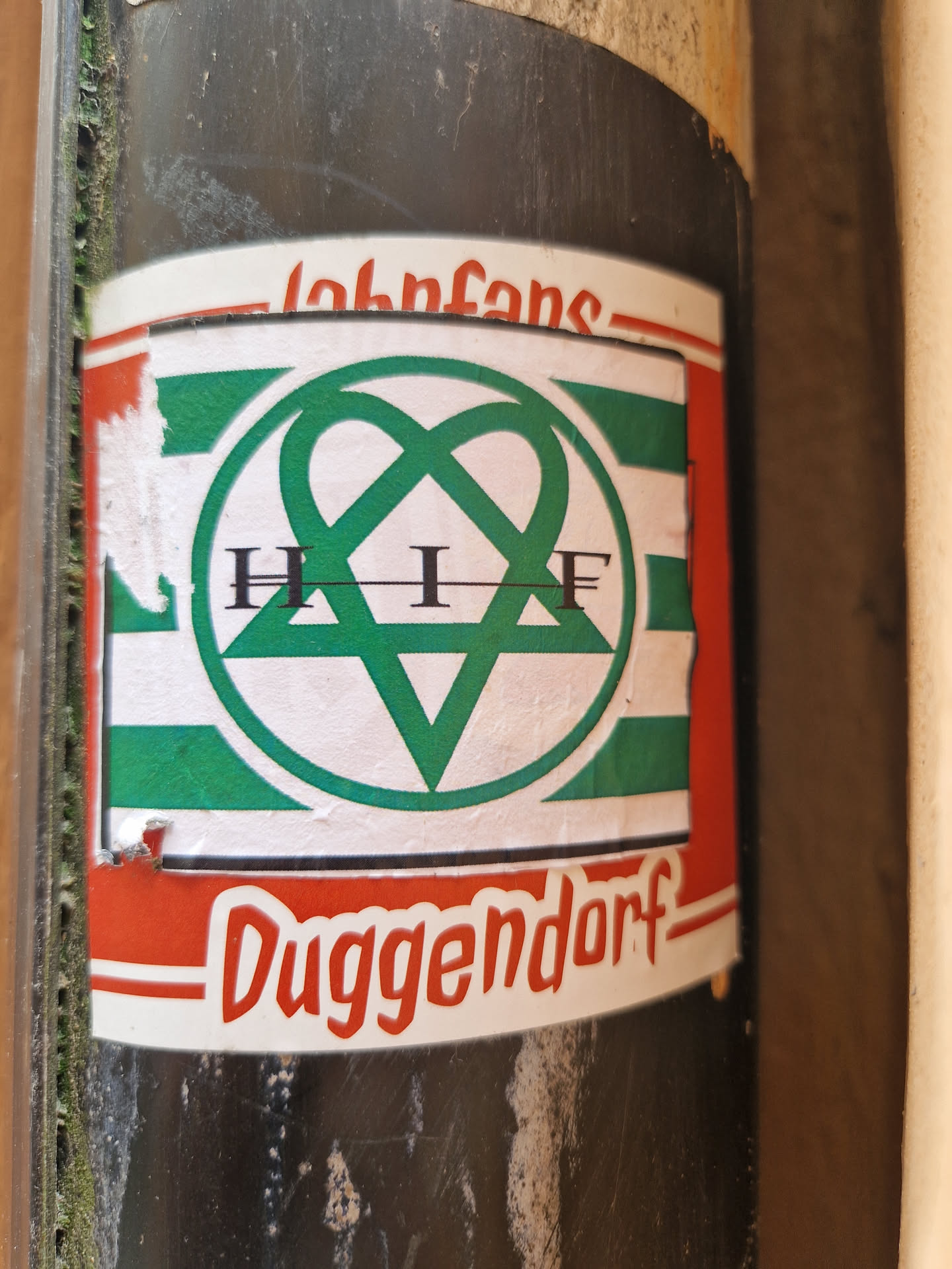 A sticker featuring the logo of H.I.F. Duggendorf, a possible band or club. The logo is a green intertwined heart shape with the letters H.I.F inside. The sticker has a red and white border with the text "Johnfans" at the top and "Duggendorf" at the bottom.