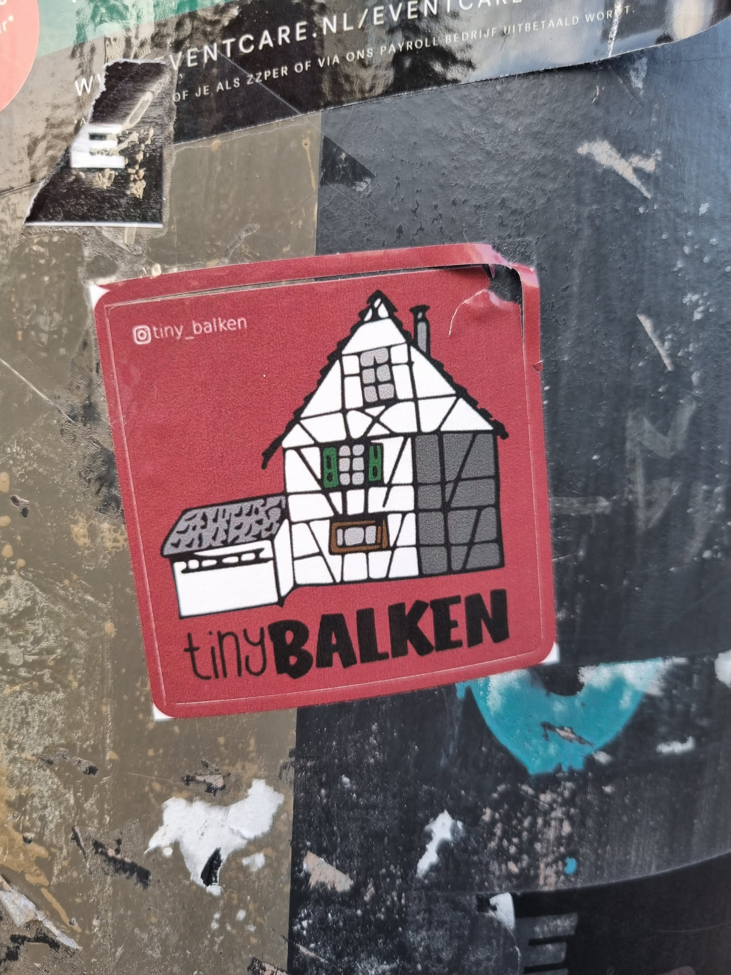Red square sticker featuring a cartoonish illustration of a tiny house, with the text "tiny BALKEN" and the Instagram handle @tiny_balken.