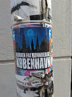 A sticker with a blue background featuring a skyline of Copenhagen under a full moon. The text reads "Klubben fra Vidunderlige København". There is a QR code at the bottom of the sticker.