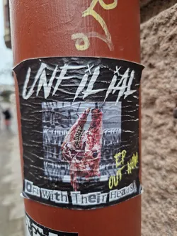 Sticker featuring artwork of two severed animal heads. Text on the sticker reads "UnfilthAl" in large letters, and "Off With Their Heads" at the bottom.  There's also "EP OUT NOW" written in a different font.