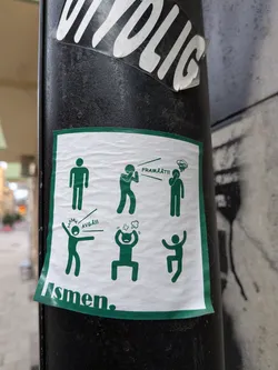 The sticker is a rectangular design with a prominent green border on a white background, adhered to a black pole. It features six minimalist green stick figures arranged in two rows of three, each depicting a different action or emotion. In the top row, from left to right: a neutral standing figure; a figure with hands covering its mouth, lines indicating speech, and the text 'FRAMÅT!!!' (Forward!!!) emanating from it; and a figure with one hand to its head, lines above indicating confusion or distress. In the bottom row, from left to right: a figure with outstretched arms, one pointing, lines indicating shouting or anger, and the text 'AVGÅ!!!' (Resign!!!) emanating from it; a crouching figure with hands to its head, lines above indicating intense anger or frustration; and a figure jumping or dancing with raised arms, appearing joyful or triumphant. Below the main grid, partially visible, is the text 'Usmen.' in green. The sticker itself shows signs of wear, with slight wrinkles and minor peeling at the edges.