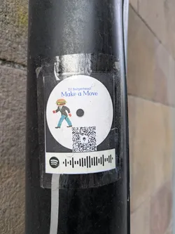 A round sticker featuring a burger-headed man in a suit walking. Above the figure is written "DJ burgerhead" and "Make a Move." Below the character, there is a QR code and a Spotify code.