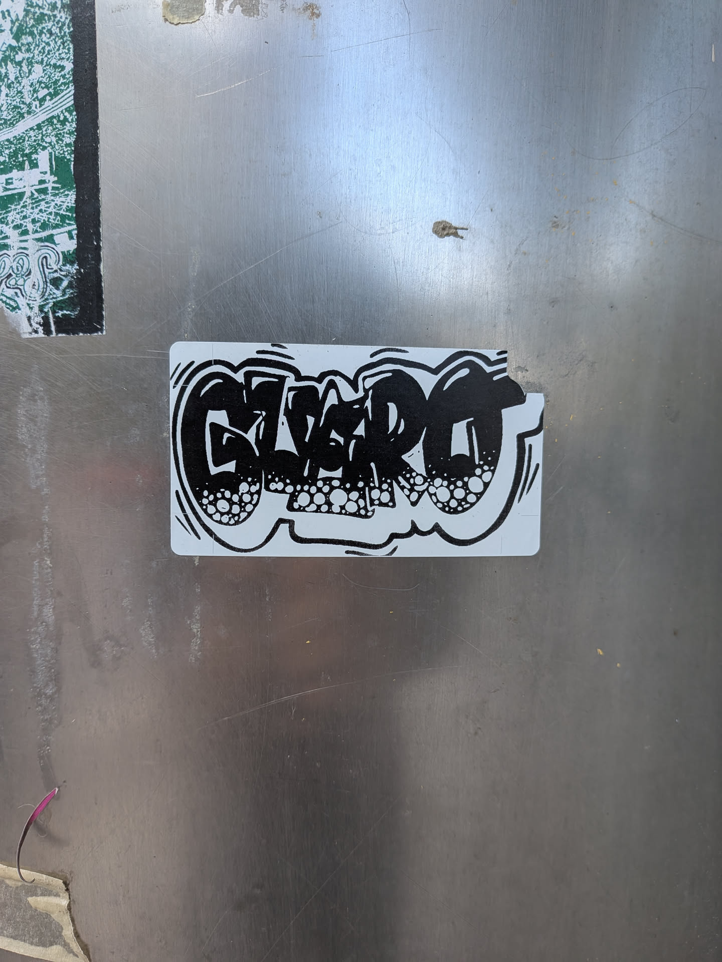 A rectangular sticker with rounded corners featuring the word 'GLEERO' in a distinctive graffiti bubble letter style. The letters are filled with solid black, outlined first in white, and then by a thicker black line. The interior of the black letters is adorned with numerous white circles of varying sizes, creating a bubbly, textured effect. The overall design is monochromatic, set against a clean white background of the sticker itself.