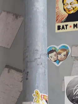 A sticker featuring a cartoon couple in a heart shape. The style is simple and sweet.