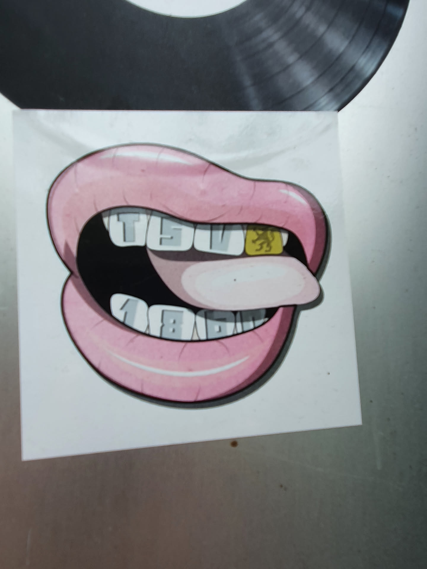 A sticker depicting a cartoon mouth with gold teeth. One tooth has the TSV 1860 München logo. The text on the other teeth spells out TSV 1860.