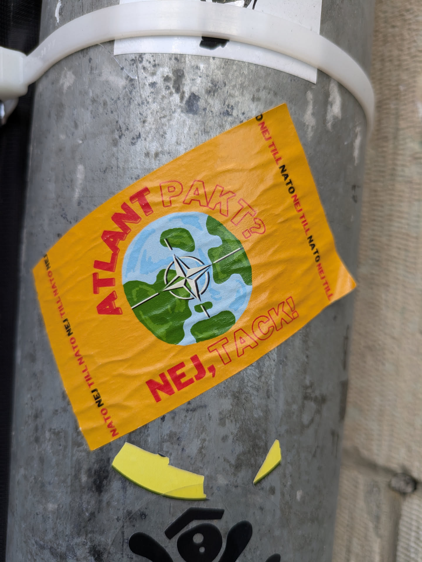 A sticker expressing opposition to the Atlantic Pact. It features a world map with a compass rose and the text "ATLANTPAKT? NEJ, TACK!" in Swedish, which translates to "Atlantic Pact? No, thank you!"