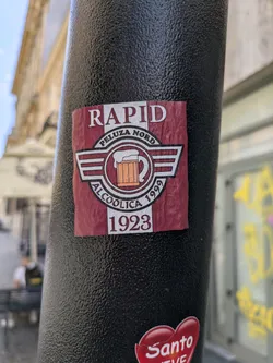 A sticker with the words 'RAPID PELUZA NORD ALCOOLICA 1999 1923' and a beer mug graphic.