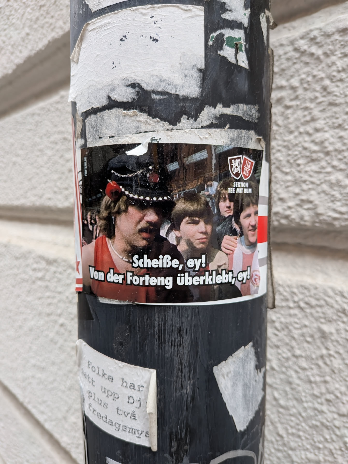 A rectangular sticker depicting a group of young men, with one wearing a decorated hat. Includes German text and a 'Sektion Tee mit Rum' logo with Fortuna Düsseldorf shields.