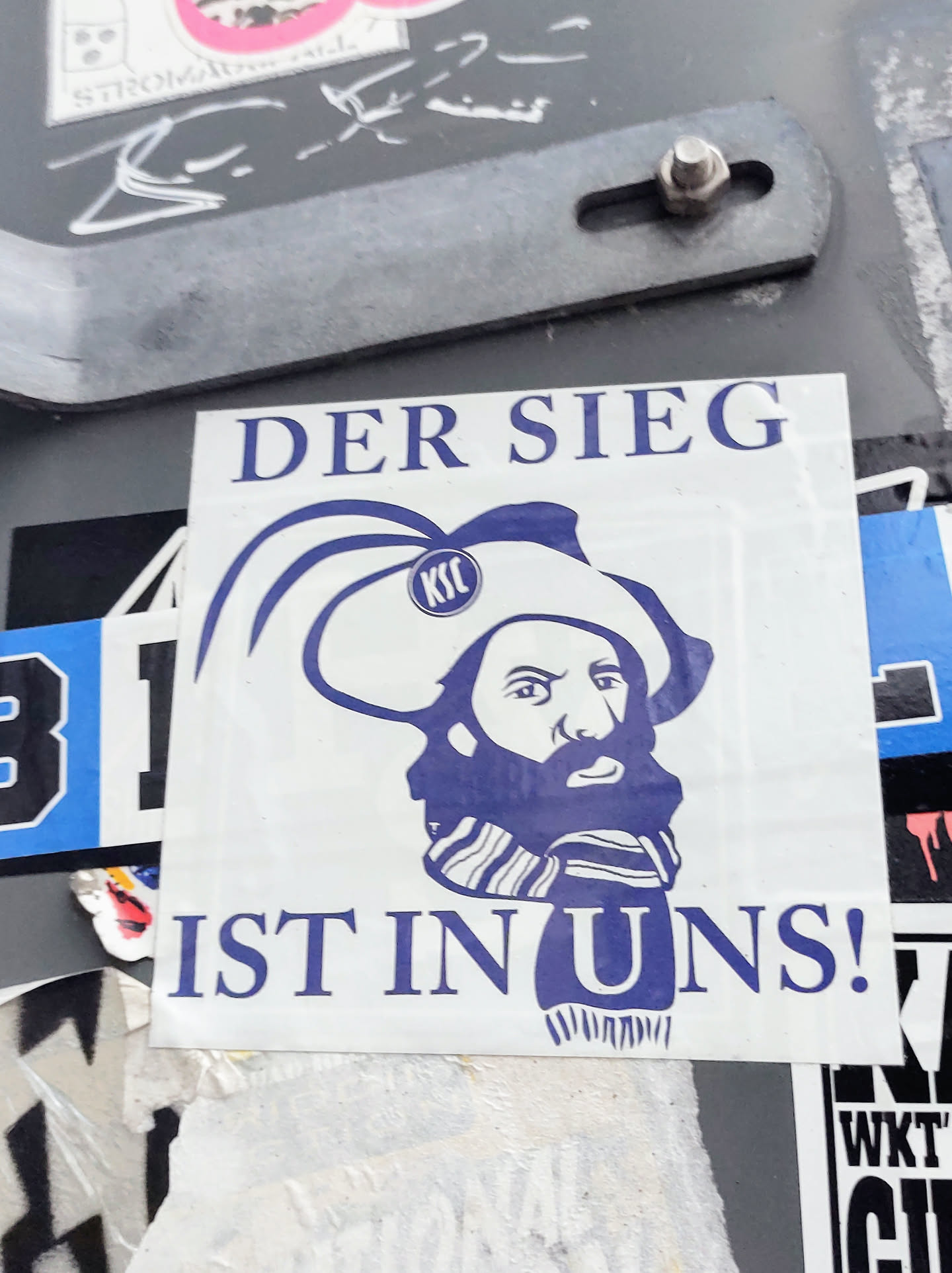 A sticker featuring a stylized illustration of a man with a beard wearing a hat, accompanied by the German phrase "Der Sieg ist in uns!" which translates to "Victory is within us!"