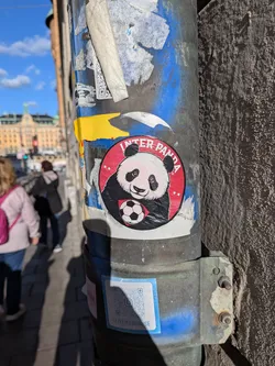 Street sticker A round sticker with a red background framed by a thin black outline. In the center, a detailed graphic illustration shows a giant panda clutching a classic black-and-white soccer ball. Arced across the top edge is the text 'INTER PANDA' in white uppercase letters, flanked by two small white stars on each side.