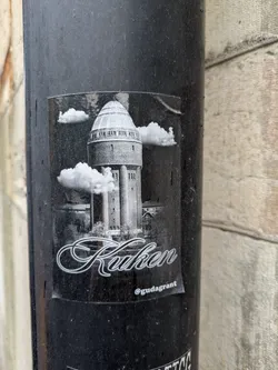 This black and white sticker shows a water tower surrounded by clouds, with the word "Kuken" below in a calligraphic font. It also includes the Instagram handle @gudagrant.