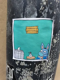 A sticker featuring a cartoon donkey wearing a facemask and reading a book, with hand sanitizer and tissues nearby. The scene is set against a teal background, with a stack of books or papers floating above.