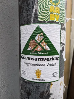 A green triangle sticker with cartoon rats and monkeys.  The text says "Gränsamverkan Neighbourhood Watch" and "Defend Söderort".  There is also a small Hammarby logo.