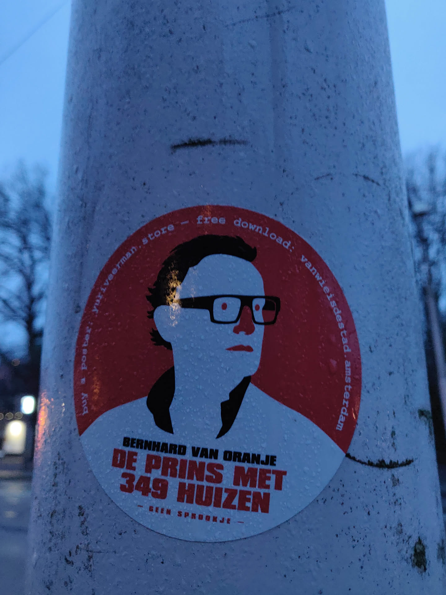 A round sticker featuring an illustration of Bernhard van Oranje with text that translates to "Bernhard of Orange - The Prince with 349 Houses" and  "Not a fairytale". It also mentions a website/store and a free download.