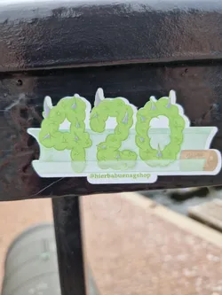 A sticker featuring the number 420 stylized as weed leaves. The number is green and has small thorns on each leaf.  The sticker includes the Instagram handle @hierbabuenaGshop at the bottom.