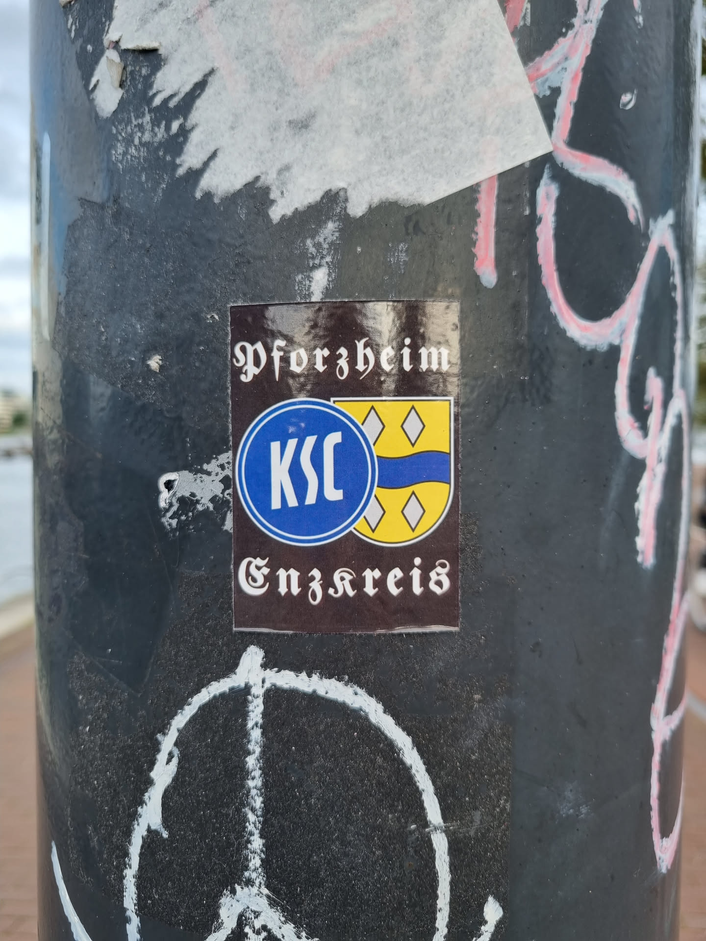 A brown sticker with the text "Pforzheim" at the top, a logo in the middle that appears to be a circular emblem with the letters KSC and a yellow and blue shield, and the text "Enzkreis" at the bottom.
