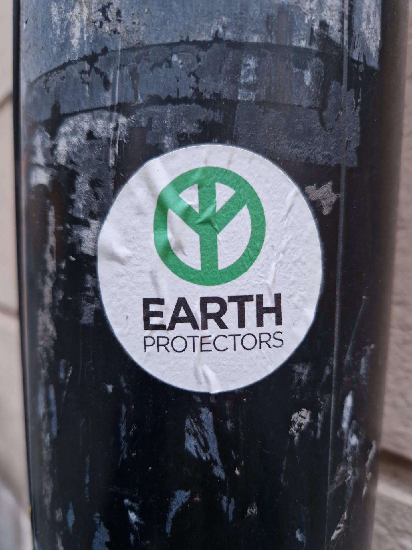 Round sticker with a green peace symbol and the text 'EARTH PROTECTORS'.