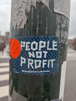 A sticker with the text "PEOPLE NOT PROFIT" on a blue background with a grid pattern.  There is a small orange circle with two parallel lines in the upper left corner. The text ©fridaysforfuture.stockholm is visible at the bottom.