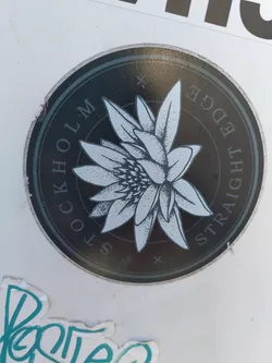 Round sticker with a flower graphic and text. The text says "Stockholm Straight Edge". The flower is stylized and detailed.