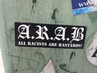 A black and white sticker with the acronym A.R.A.B. standing for All Racists Are Bastards! The text is written in an old English style font.