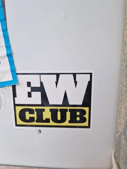 A black and yellow sticker with the text "EW CLUB" in bold, uppercase letters. The letters "EW" are larger than the word "CLUB".