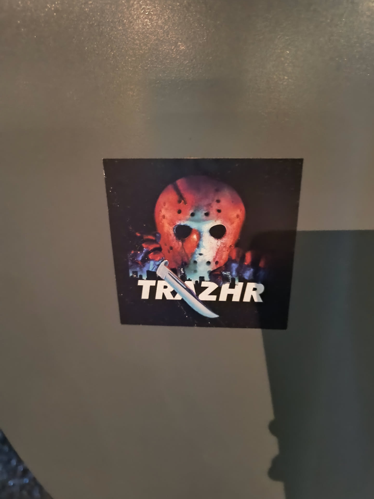 A sticker featuring Jason Voorhees' hockey mask and machete from the Friday the 13th franchise. The word TRZHR is printed below the image.