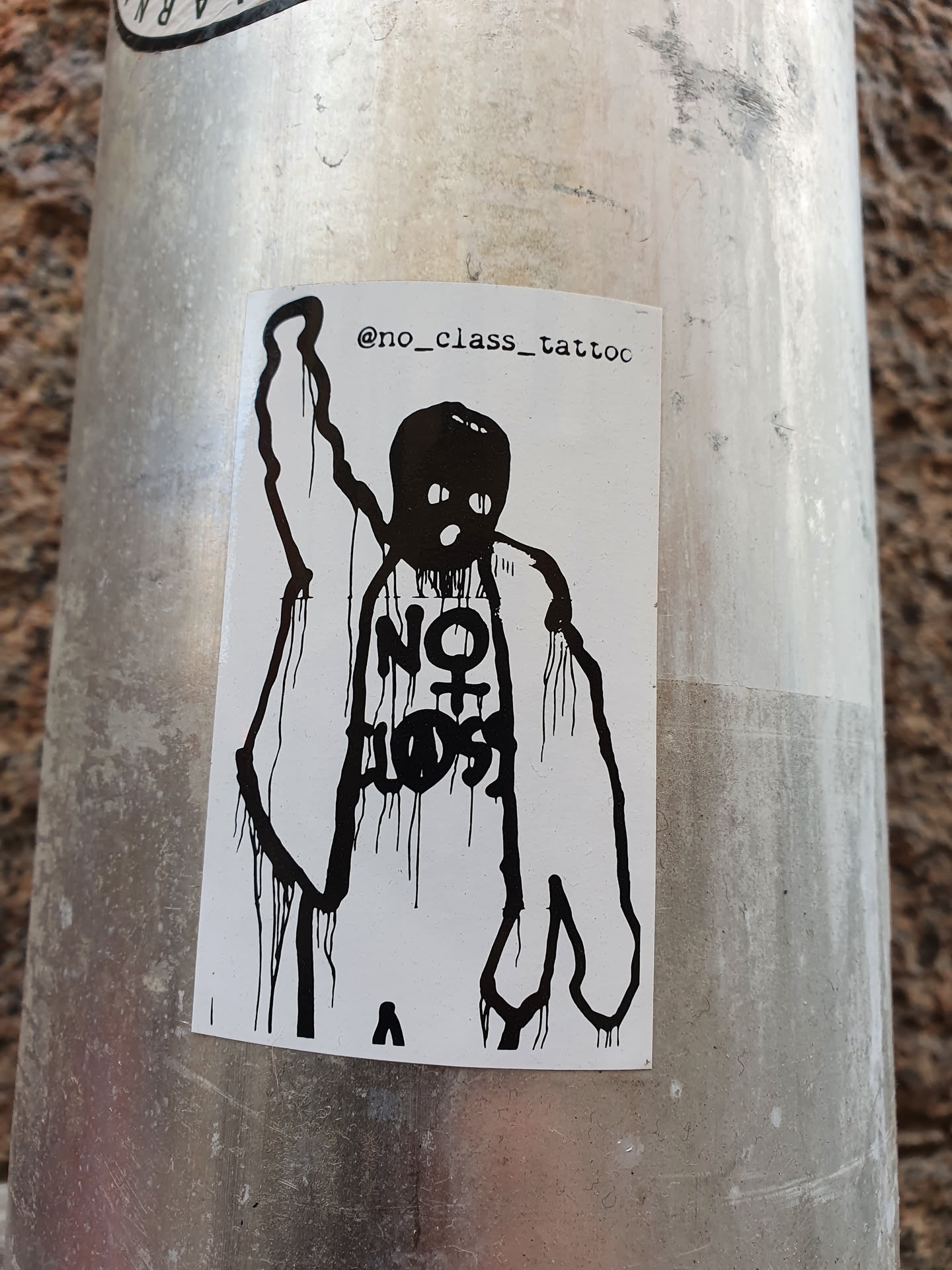 Black and white sticker of a person with their fist raised, wearing a jacket and what seems to be a balaclava. The text on their shirt says "NO CLASS". The artist's Instagram handle is in the top right corner.