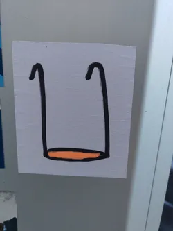 A minimalist sticker featuring a drawing of a swing. The swing is depicted with two black lines for the sides and an orange line at the bottom for the seat. The style is childlike and simple. 